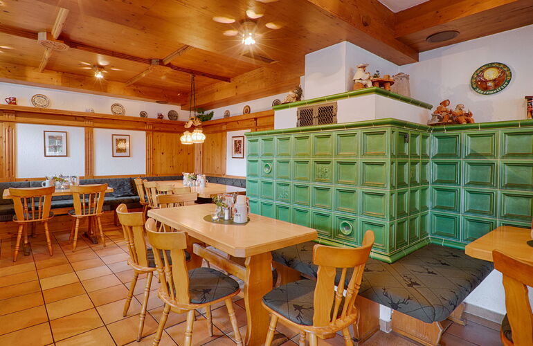 Holzgetäfelte Gaststube mit Kachelofen im Spießberghaus